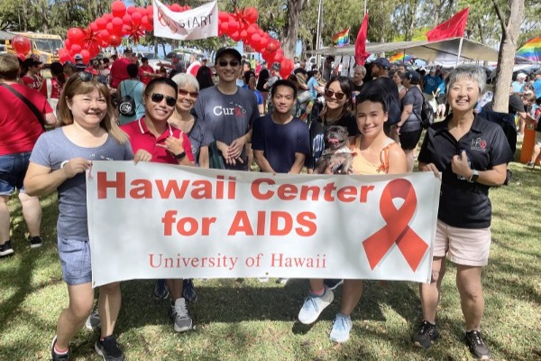 A GROUP OF PEOPLE HOLDING AN AIDS BANNER.